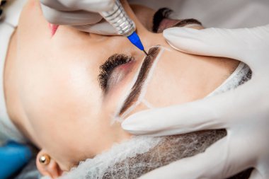 Kalıcı makyaj kaşları için. Güzel kadının güzellik salonu içinde kalın kaşları ile portre. Şevval özçelik güzellik kadın yüzü için kaş dövme yapıyor. Güzellik yordamı.