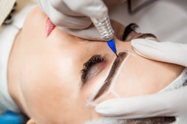 Kalıcı makyaj kaşları için. Güzel kadının güzellik salonu içinde kalın kaşları ile portre. Şevval özçelik güzellik kadın yüzü için kaş dövme yapıyor. Güzellik yordamı.