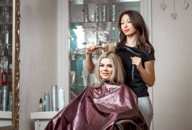 Saç kurutma makinesi Kuaför Salonu arka plan üzerinde istemcinin hairdoing yaparken şık profesyonel, Kuaför