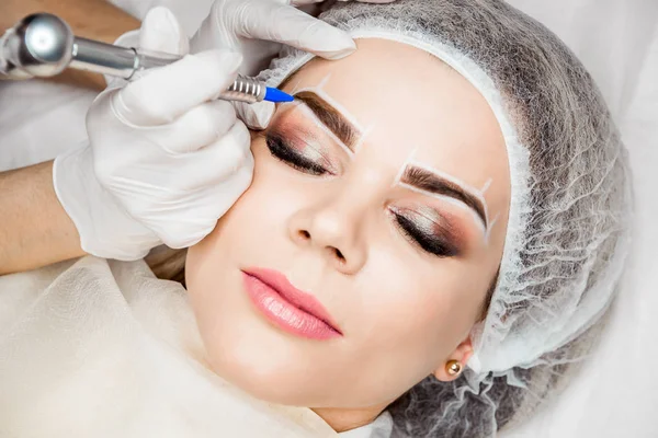 Permanent Makeup för ögonbryn. Närbild av vacker kvinna med tjocka ögonbryn i skönhetssalong. Kosmetolog gör ögonbryn tatuera för kvinnliga ansikte. Skönhet förfarande. — Stockfoto