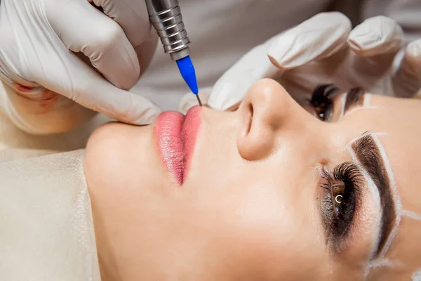 Healthy Spa. Joven hermosa mujer teniendo permanente maquillaje tatuaje en sus labios —  Fotos de Stock