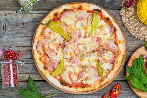 Pizza met tomaten, mozzarella kaas, zwarte olijven en basilicum. Heerlijke Italiaanse pizza op houten pizza bord. — Stockfoto