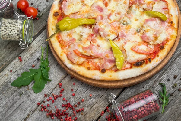 Pizza com tomate, queijo mussarela, azeitonas pretas e manjericão. Deliciosa pizza italiana em tábua de pizza de madeira . — Fotografia de Stock