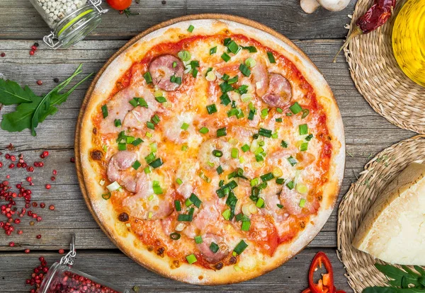 Pizza met tomaten, mozzarella kaas, zwarte olijven en basilicum. Heerlijke Italiaanse pizza op houten pizza bord. — Stockfoto