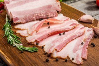Slices of bacon on the wooden background clipart