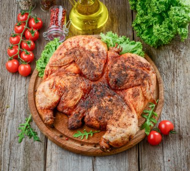 Izgara kızarmış kızarmış tavuk tütün kesme tahtası, baharat ve sebze ile