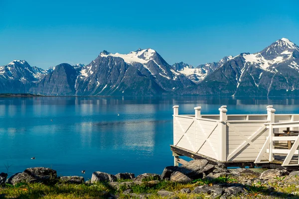 Místo pro odpočívadli, dřevěné dekorace a norské vlajky na břehu fjordu jezera. Dovolená relaxace na cestách. Skandinávie Evropa. — Stock fotografie