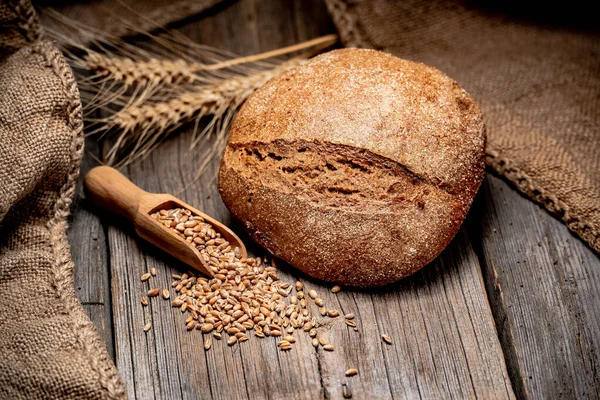 Pão tradicional acabado de assar na mesa de madeira — Fotografia de Stock