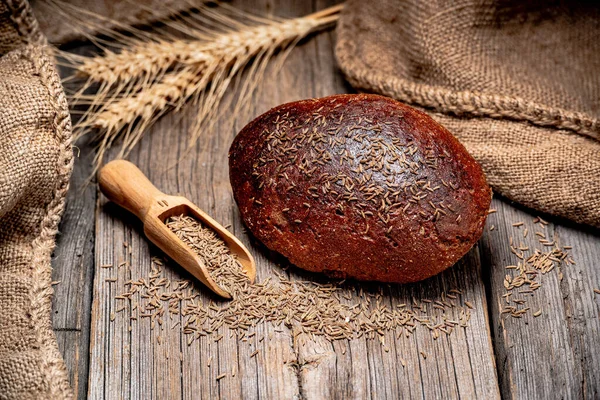 Broodpitten met rogge. Vers gebakken traditioneel brood op houten tafel. — Stockfoto