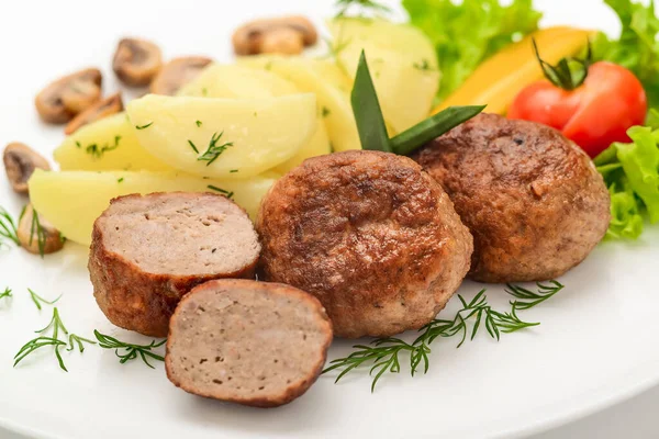 Costeletas caseiras com batatas e legumes em um fundo branco . — Fotografia de Stock