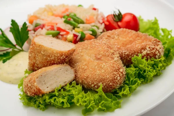 Chicken cutlets in batter with risotto and vegetables