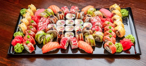 Sushi Set - Maki Sushi alaskan roll, yin yang roll and Nigiri Sushi tuna, salmon, eel . On wooden background