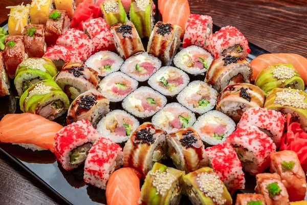 Sushi Set - Maki Sushi alaskan roll, yin yang roll and Nigiri Sushi tuna, salmon, eel . On wooden background