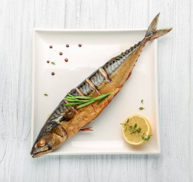 Fırınlanmış balık, sebzeli ve limonlu ızgara menü için beyaz arka planda.