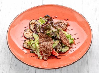 Beyaz tabakta taze sebze salatasıyla ızgara domuz eti. bir yatay görünümün üst görüntüsü