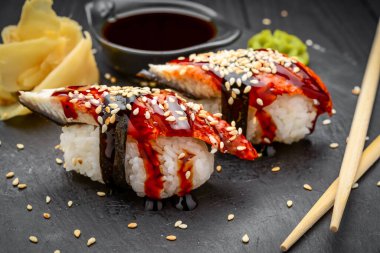Siyah arka planda yılan balığı olan nigiri sushi, geleneksel Japon yemeği.