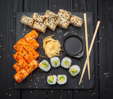 Sushi set nigiri ve suşi ruloları siyah taş levhada servis edilir, geleneksel Japon yemekleri.