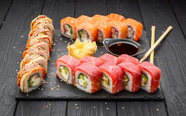 Sushi set nigiri ve suşi ruloları siyah taş levhada servis edilir, geleneksel Japon yemekleri.