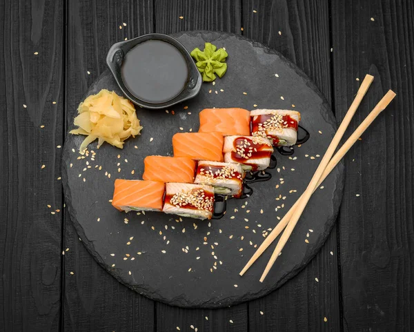 Sushi Rulle Med Och Lax Stenplatta Över Svart Bakgrund — Stockfoto