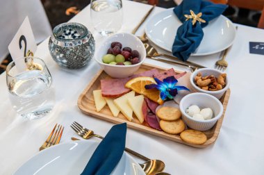 Tasty appetizer platter!. A beautifully arranged appetizer platter features cheeses, cured meats, fruits, and nuts, set for a social event.