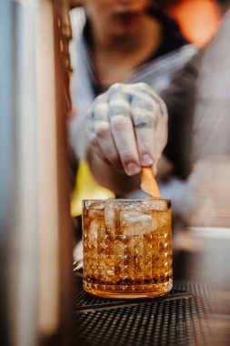 New York, ABD, 8 Temmuz 2025: Barmen bir barda kokteyl hazırlıyor. Bir barmen, akşam saatlerinde loş bir bardaki kokteyle garnitür ekliyor..