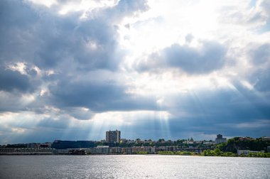 Sunlight breaking through clouds in Manhattan. Sunlight breaks through clouds over Manhattan waterfront, creating a calming atmosphere on a cloudy day.