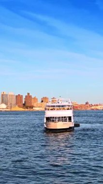 New York, ABD, 1 Temmuz 2025: New York 'taki East River feribotu. Bir şehir feribotu Doğu Nehri boyunca hareket eder. Binalar arka plandaki rıhtım hattında..