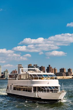 Yolcu feribotu mavi gökyüzü ile Hudson Nehri 'nden geçiyor. Beyaz bir yolcu feribotu açık mavi gökyüzünün altında Hudson Nehri 'nden geçiyor..