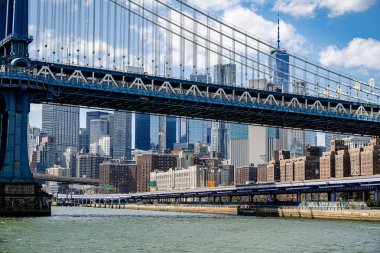 Gündüz vakti New York silueti olan Manhattan Köprüsü. Manhattan Köprüsü, arka planda Manhattan gökdelenleriyle Doğu Nehri 'nin üzerine uzanır..