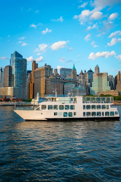 Hudson Nehri kıyısında Manhattan silueti olan beyaz feribot. Beyaz bir feribot Manhattan 'ın rıhtımına yakın Hudson Nehri boyunca yol alır..