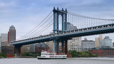 New York, ABD, 16 Temmuz 2025: Manhattan Köprüsü Doğu Nehri 'nde Circle Line yolcu gemisi ile. Arka planda New York mimarisi olan bir Circle Line yolcu gemisi Manhattan Köprüsü 'nün altından geçiyor..