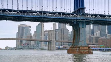 New York silueti olan Brooklyn ve Manhattan Köprüleri. Brooklyn ve Manhattan Köprüleri New York 'un gökdelenleriyle Doğu Nehri' ni geçiyor.