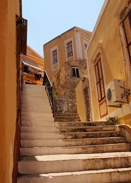 Symi, stone stairs and colorful houses in a street of Ano Symi, Symi island, Greece