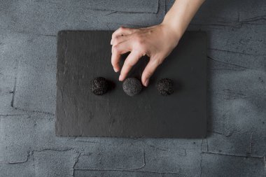 bir şeker toplama el ile siyah taş gemide minimalist doğal ham tatlılar