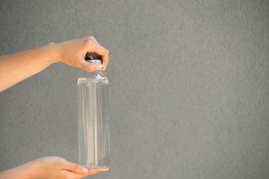 Kadının elinde temiz su dolu cam bir şişe var.