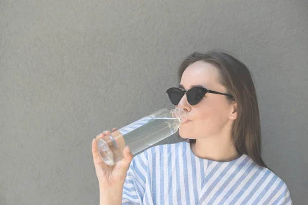 Donna tiene bottiglia di vetro con acqua limpida — Foto Stock