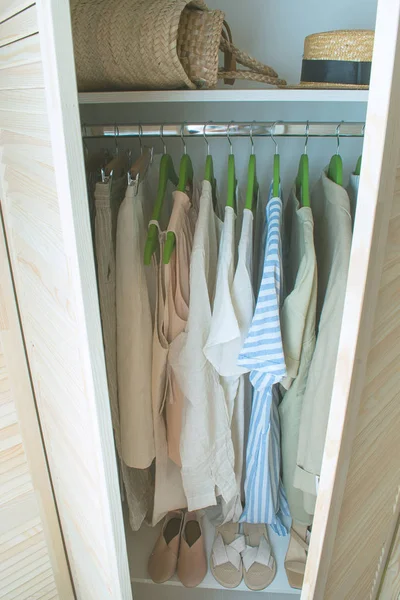 Guarda-roupa de verão com roupas de linho em cabides verdes — Fotografia de Stock