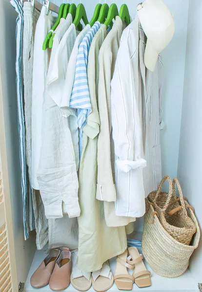 Armario de verano con ropa de lino en perchas verdes — Foto de Stock