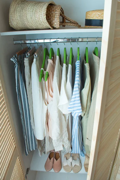 Guarda-roupa de verão com roupas de linho em cabides verdes — Fotografia de Stock