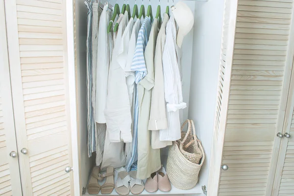 Zomergarderobe met linnen kleding op groene hangers — Stockfoto