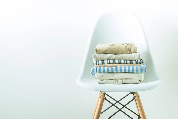 Pegada de ropa doblada en una silla moderna y blanca —  Fotos de Stock