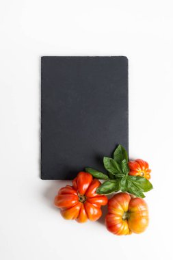 Kopya alanı için siyah tahtası olan kırmızı organik domates ve casuslar.