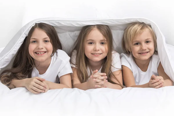 Tres Niños Sonrientes Felices Bajo Manta Casa —  Fotos de Stock