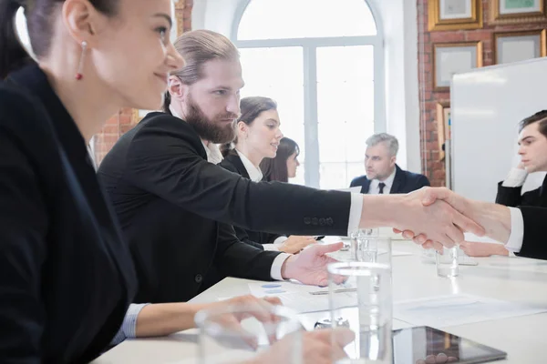 ビジネス人々 ドキュメントと行と仕事でテーブルに座って握手 — ストック写真