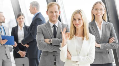 Successful business team with arms crossed at the office, woman showing ok sign clipart