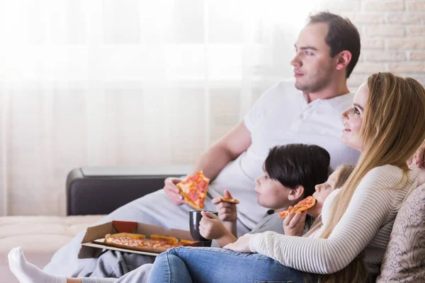 Jovens Pais Seus Filhos Estão Assistindo Comendo Pizza Sorrindo Enquanto — Fotografia de Stock
