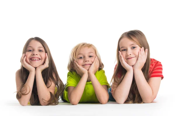 Ευτυχής Χαμογελαστοί Τρία Παιδιά Πολύχρωμα Ρούχα Τοποθέτηση Πατωμάτων Που Απομονώνονται — Φωτογραφία Αρχείου