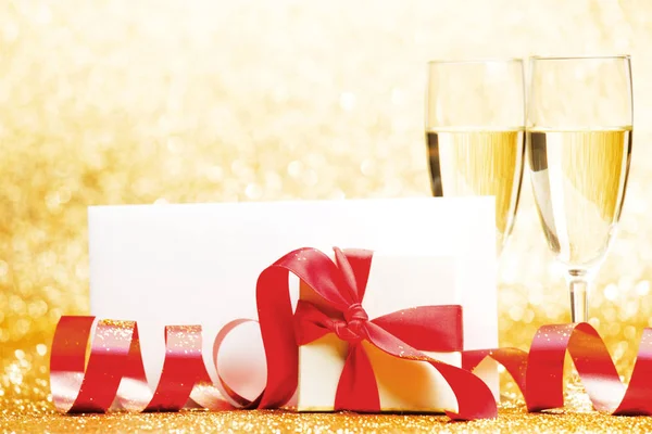 Champagnergläser Und Geschenk Whitebox Mit Roter Schleife Auf Goldenem Hintergrund — Stockfoto