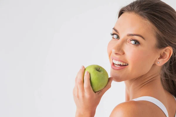 白背景に青リンゴを保持して健康な白い歯と美しい女性 — ストック写真