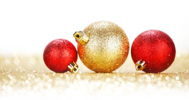 Three chritmas balls on glitters isolated on white background clipart